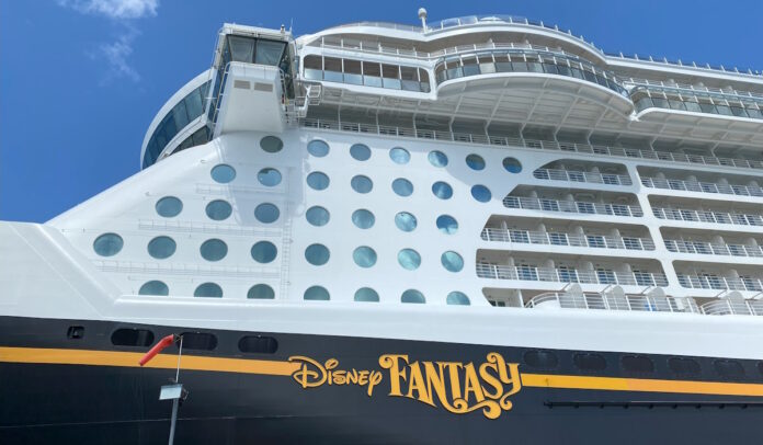 Side of the Disney Fantasy docked at port.