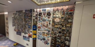 Disney Cruise Line Updates Door Decorating Policy to Ban Hallways and Ceilings Family pictures cover a wall outside a Disney Cruise Line stateroom door.